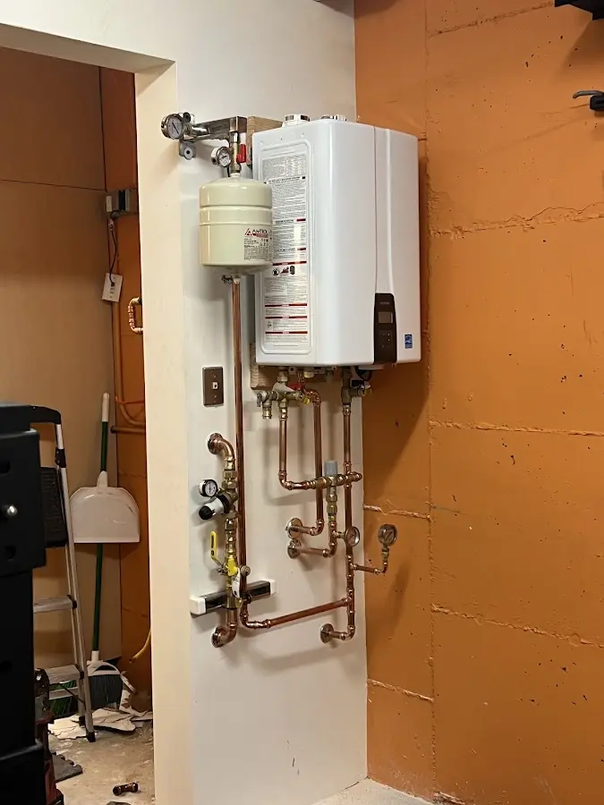 Plumbing technician inspecting water heater connections in Humboldt